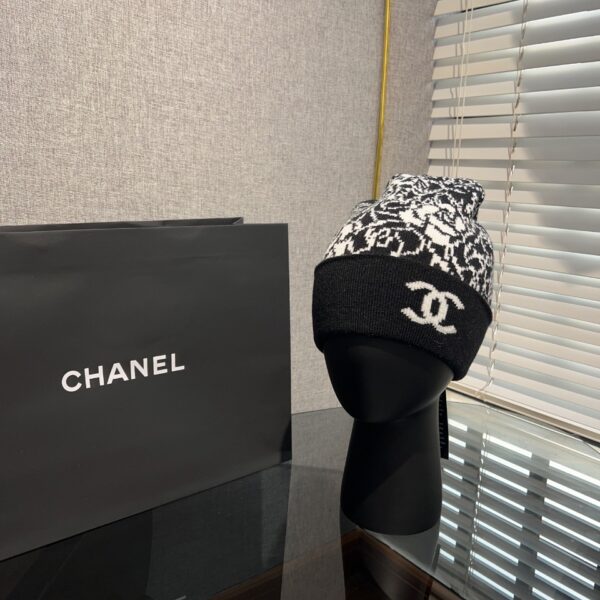 CHANEL – Bonnet Tricoté 23K Noir et Blanc avec Broche Camélia: Un Accessoire Hivernal Chic