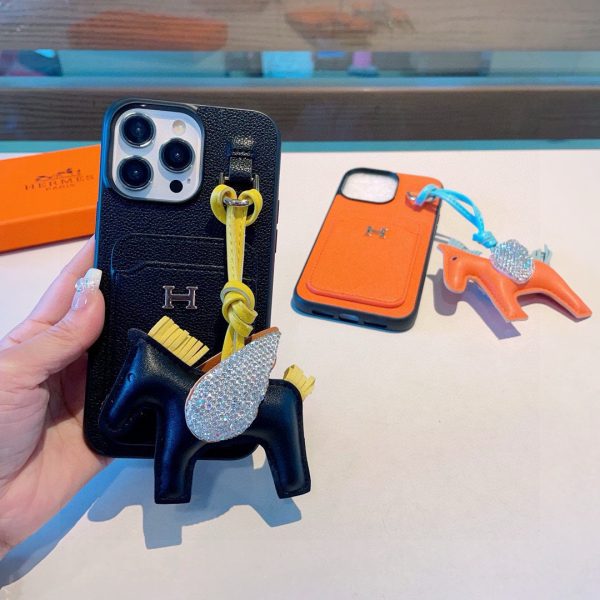 Hermès – Étui de téléphone avec porte-cartes intégré et pendentif cheval, duo luxe et fonctionnel